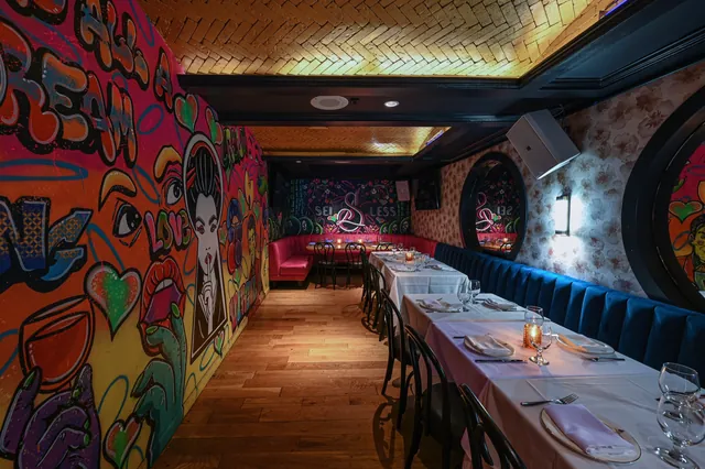 Navy banquettes and a round window along the dining table in the Graffiti Room at Sei Less