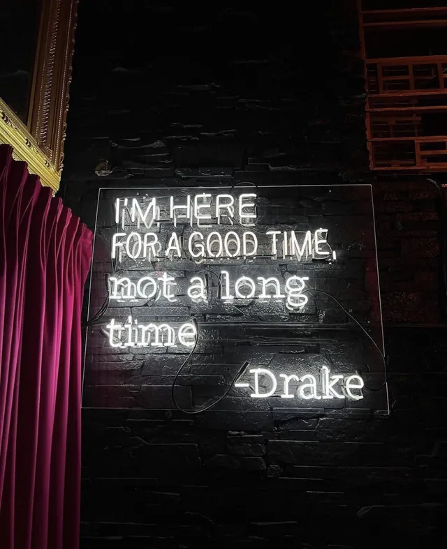 A neon sign inside Sei Less that reads “I’m here for a good time, not a long time”