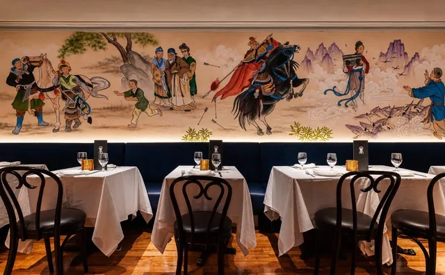 The Mulan mural in the dining room The hand-painted Mulan mural above the navy banquette and white-linen tables in the dining room at Sei Less, Midtown Manhattan