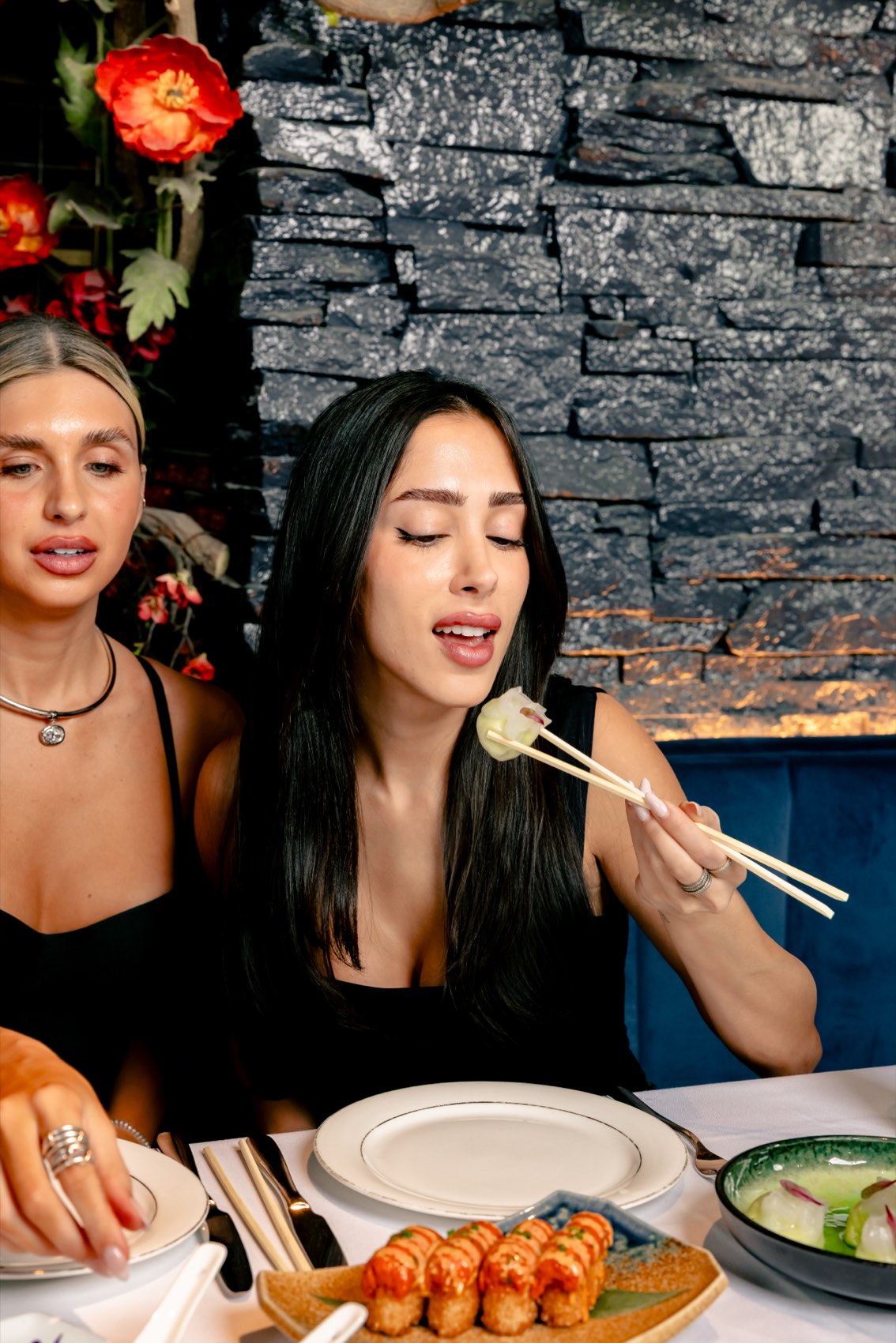 Guests sharing dumplings and sushi rolls at Sei Less, Asian fusion dining in Midtown Manhattan